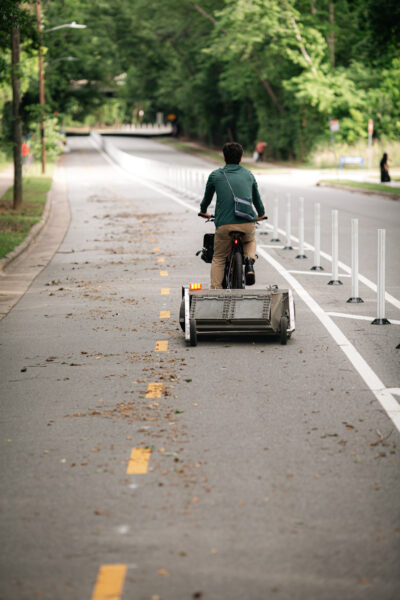 Bicyclist pull a custom bike lane sweeper behind him