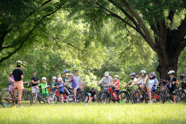 Group of kids listening to an instructor talk at a mountain biking class