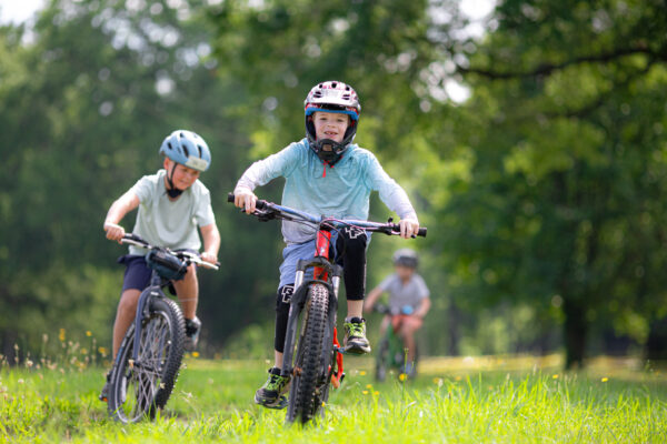 Kids riding in the grass on mountain bikes
