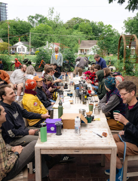 people around a table outside drinking coffee